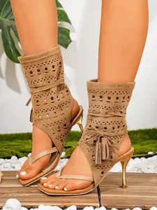 Detailansicht von braunen Wildleder-Stilettosandalen mit Fransen und Zehentrenner