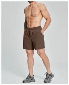 Detailed view of men's brown stretch quick-dry athletic shorts on a muscular model