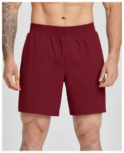 Front view of men's burgundy athletic shorts on fitness model, quick-dry stretchy fabric