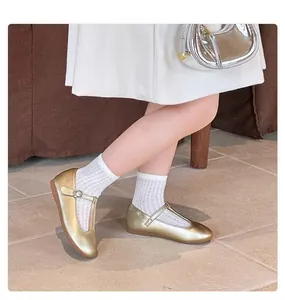 Close-up detail view of gold metallic T-strap flat shoes for girls in vintage princess style