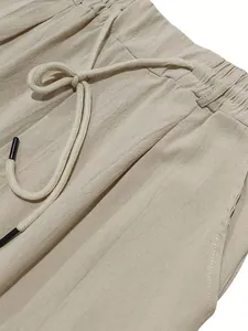 Detailaufnahme der Leinenstoffstruktur und des Kordelzugs einer beigen Herrenhose