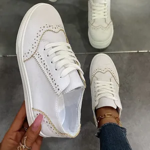 Λεπτομερής προβολή λευκών sneakers πλατφόρμας με κομψές σκαλιστές λεπτομέρειες brogue