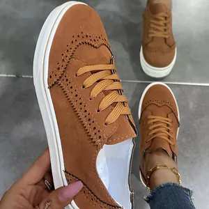 Λεπτομερές κοντινό πλάνο καφέ σουέντ brogue sneakers με λευκή σόλα πλατφόρμας.