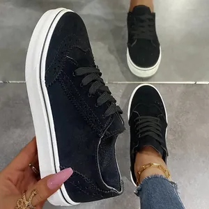 Λεπτομερής προβολή μαύρων σουέντ sneakers με σχέδια brogue και χοντρές λευκές σόλες.