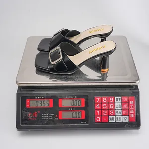 Black square-toe high heel mule with buckle showing a weight of 0.355kg on scale.