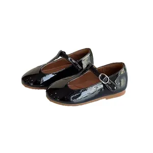 Black patent leather T-strap shoes for girls with retro Mary Jane style and buckle strap.