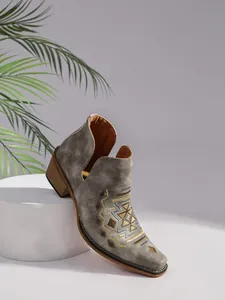Vue détaillée de bottines Chelsea grises avec broderies et talon en bois.
