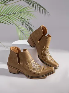 Vue détaillée des bottines Chelsea beiges avec broderie géométrique et talon en bois