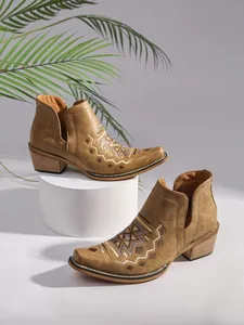Vue détaillée de bottines Chelsea marron avec broderies et talons façon bois.