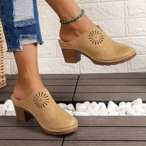 Close-up of tan heeled clogs with intricate laser-cut sunburst pattern details.