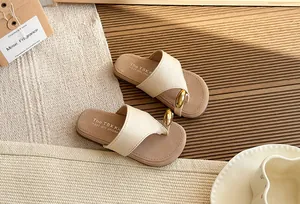 Vista detallada de chanclas beige estilo hada con suela gruesa y acento de metal dorado para mujer