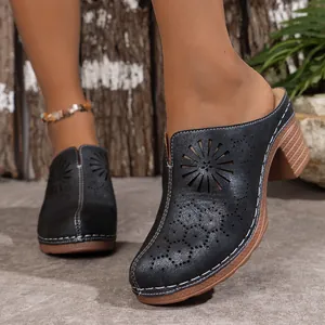 Close-up view of black cutout high heel mules featuring elegant flower pattern details