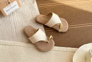 Elegantes sandalias de dedo color crema con bola dorada decorativa y suela cómoda