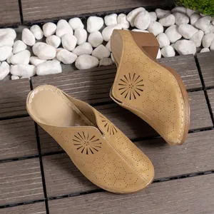 Detailed view of yellow closed-toe wedge mules with sunburst laser-cut pattern.