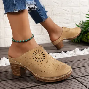 Close-up of stylish tan closed-toe wedge mules with laser-cut patterns on a deck