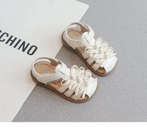 Detailansicht der cremefarbenen Mädchensandalen mit mehrlagiger Schleife für Kinder