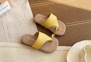 Primer plano de chanclas amarillas de estilo hada con un elegante detalle de aro dorado