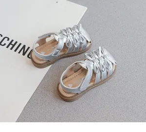 Detailansicht von silbernen Mädchen-Sandalen mit süßen Schleifen im Prinzessinnen-Stil
