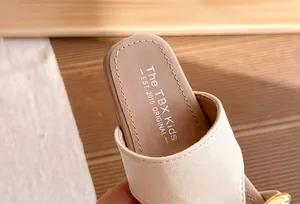 Detalle macro de la plantilla de una sandalia beige con el logotipo de The TBX Kids