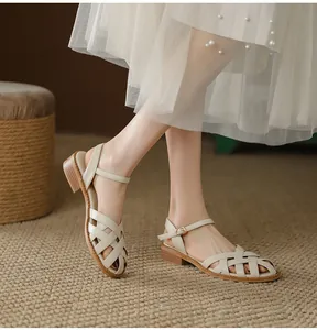 Elegant beige woven leather Roman sandals worn by a model against a retro backdrop