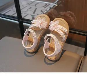 Detailansicht der rosa Mädchensandalen mit eleganten Stoffblumen und Perlenverzierungen