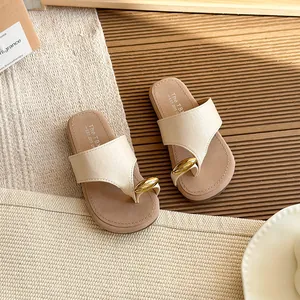 Elegantes sandalias de dedo beige para mujer con un detalle de anillo dorado chic.