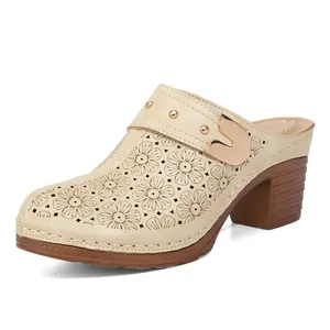 Elegant beige women's chunky heel clogs with floral laser-cut details on white background