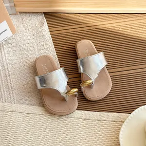 Elegantes sandalias plateadas con hebilla dorada y suela gruesa para la playa en verano