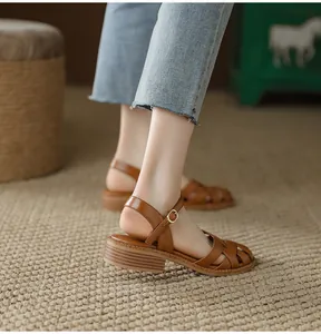 Close-up of brown French retro woven leather sandals with block heel and buckle strap