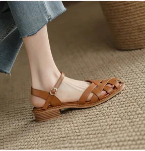 Close-up detail of a brown leather woven sandal with a stylish vintage block heel.