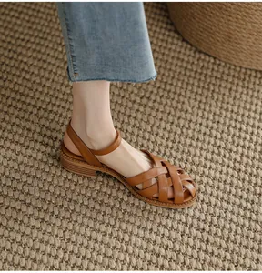 Detail shot of brown French retro woven leather sandals with a stable block heel.