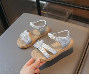 Detailansicht der silbernen Mädchensandalen mit eleganten Perlen und weißem Blumendekor