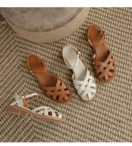 Detailed view of French retro woven leather sandals in brown and off-white finishes