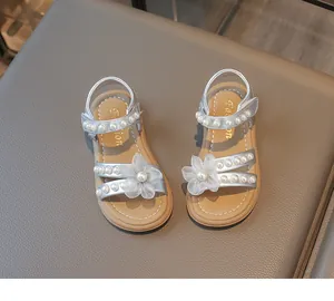 Detailansicht silberner Mädchensandalen mit Perlenverzierung und eleganter Spitzenblume