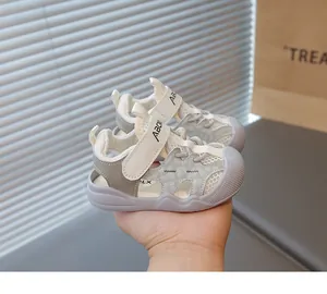 Detailed view of grey mesh toddler sandals with soft non-slip soles held in hand.