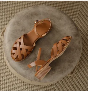 Detailed top view of brown woven leather sandals with chunky heels and ankle straps.