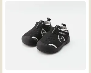 Vista detallada de sandalias negras para niños con agujeros transpirables y suelas blandas