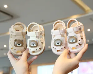 Detailed view of pink and beige baby sandals featuring cute bear design and soft soles