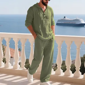Detailansicht des olivgrünen Leinen-Freizeitsets für Herren mit Kapuze auf einem Balkon.