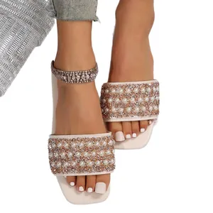 Elegant women's flat slides featuring a wide strap with pearls and rose gold glitter.
