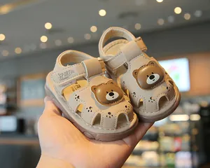 Detail view of beige baby walking sandals featuring a cute cartoon bear and closed-toe
