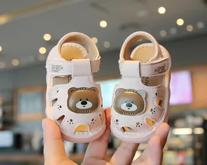 Close-up of pink toddler sandals with cute cartoon bear decoration and sport strap.
