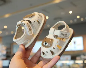 Detailed view of cream baby sandals with cute cartoon bear and soft non-slip soles