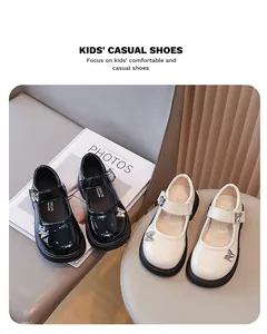 Detailansicht glänzender Mary Jane Kinderschuhe in Schwarz und Beige mit Schmetterling