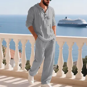 Detailansicht eines grauen Leinen-Sets mit Kapuze für Herren auf einem sonnigen Balkon.