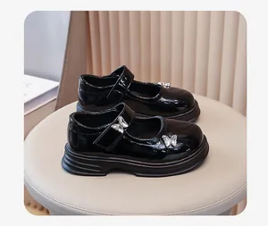 Glänzende schwarze Mary Jane Schuhe für Mädchen mit silbernen Schmetterlingen.