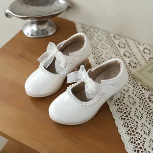 Elegant white girls' princess shoes featuring lace bow and pearl trim with glitter heel detail