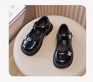 Detailansicht der schwarzen Lackleder-Mary Janes für Mädchen mit Schmetterlingsdekor