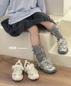 Dettaglio di scarpe da ginnastica argento per bambine con perle e fiocchi chic
