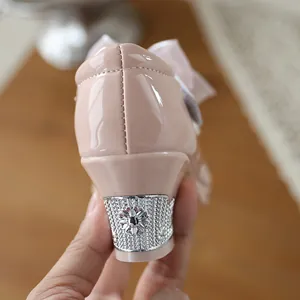 Detailed view of ornate silver floral heel on pink patent leather girls' dress shoes